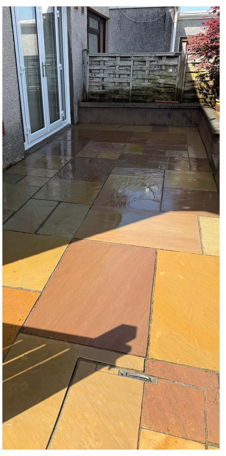 The same patio after cleaning, revealing colourful Indian sandstone